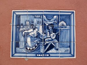 dettagli di un azuleio di color azzurro e bianco, dedicato al Fado dove si vedono chitarristi e ballerini